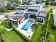 Aerial view of the home with a large backyard, pool, solar panels, manicured landscaping, and outdoor dining at 14106 Eliot Ave, Orlando, FL 32827