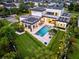 Aerial view showcases a modern home with a solar panel roof, pool, manicured lawn, and landscaping at 14106 Eliot Ave, Orlando, FL 32827