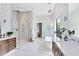 Bright bathroom featuring a walk-in shower, soaking tub, and dual vanity sinks with marble countertop and modern fixtures at 14106 Eliot Ave, Orlando, FL 32827
