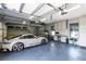 Spacious garage with an epoxy floor, organized storage solutions, and a sleek white sports car at 14106 Eliot Ave, Orlando, FL 32827