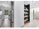 Hallway featuring built in shelves, light hardwood floors, and stainless steel refrigerator at 14106 Eliot Ave, Orlando, FL 32827