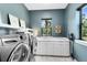 Well-organized laundry room with modern washer and dryer, ample counter space, and natural light at 14106 Eliot Ave, Orlando, FL 32827