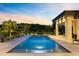 Serene backyard pool at dusk with illuminated water, surrounded by lush greenery and lounge chairs at 14106 Eliot Ave, Orlando, FL 32827