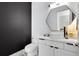 Modern powder room with black accent wall, geometric mirror, and vessel sink on a white vanity at 14106 Eliot Ave, Orlando, FL 32827