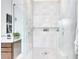 Close-up view of the glass-encased shower highlighting its rainfall showerhead, and tiled wall with recessed niche at 14106 Eliot Ave, Orlando, FL 32827