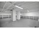 Large open basement space with painted concrete floor, white support columns, utility hookups and built-in shelving at 1510 Live Oak St, New Smyrna Beach, FL 32168