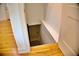 Stairway leading to basement has newly refinished hardwood floors, new paint, and a white door at 1510 Live Oak St, New Smyrna Beach, FL 32168