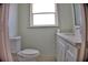 Charming bathroom featuring a toilet, single sink, and a window providing natural light at 1510 Live Oak St, New Smyrna Beach, FL 32168
