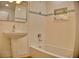 Updated bathroom with a pedestal sink, tiled shower and tub, and a stylish mirror at 1510 Live Oak St, New Smyrna Beach, FL 32168