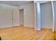 A bright bedroom featuring hardwood floors, crisp white trim, and natural light from an open closet and doorway at 1510 Live Oak St, New Smyrna Beach, FL 32168