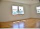 A well-lit room showcases beautiful hardwood floors and two large windows with natural light at 1510 Live Oak St, New Smyrna Beach, FL 32168