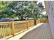 Long wooden deck surrounded by a wooden railing overlooking the spacious green backyard and mature trees at 1510 Live Oak St, New Smyrna Beach, FL 32168