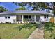 Lovely exterior view of home featuring a quaint front porch and beautiful landscaping at 1510 Live Oak St, New Smyrna Beach, FL 32168