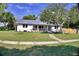 Charming home with a metal roof, a lovely landscaped front yard, and green lawn at 1510 Live Oak St, New Smyrna Beach, FL 32168