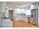 Bright kitchen boasts white cabinetry, stainless steel appliances, and hardwood floors at 1510 Live Oak St, New Smyrna Beach, FL 32168