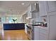 Modern kitchen with stainless steel range, white cabinets, island, and hardwood floors at 1510 Live Oak St, New Smyrna Beach, FL 32168
