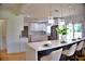 Bright, updated kitchen features quartz counters, stainless appliances, hardwood floors and a breakfast bar with pendant lighting at 1510 Live Oak St, New Smyrna Beach, FL 32168