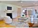 Cozy living room with fireplace, hardwood floors, ceiling fan, and open view to kitchen at 1510 Live Oak St, New Smyrna Beach, FL 32168
