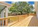Backyard with wooden deck featuring wooden railing and mature landscaping, enhancing privacy and outdoor enjoyment at 1510 Live Oak St, New Smyrna Beach, FL 32168