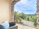 Charming balcony with stone archway offering serene views of the golf course and palm trees at 16246 Ravenna Ct, Montverde, FL 34756
