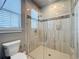 Modern bathroom features glass shower with sleek tile and a window letting in natural light at 16246 Ravenna Ct, Montverde, FL 34756