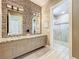 Elegant bathroom with double vanity sinks and a walk-in shower with stylish tile work at 16246 Ravenna Ct, Montverde, FL 34756