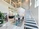 Elegant dining area adjacent to a staircase, with views of the kitchen and contemporary decor at 16246 Ravenna Ct, Montverde, FL 34756