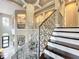Elegant foyer showcases a grand staircase with decorative metal railing and a stunning chandelier at 16246 Ravenna Ct, Montverde, FL 34756