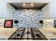 Close-up of the kitchen with a stainless steel gas range and decorative backsplash at 16246 Ravenna Ct, Montverde, FL 34756
