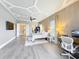 Expansive bedroom with tray ceiling, stylish decor, and a view into an office space at 16246 Ravenna Ct, Montverde, FL 34756