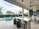 Beautiful outdoor kitchen and pool area with bar seating and lush landscaping at 16246 Ravenna Ct, Montverde, FL 34756