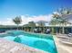Sparkling pool and spa with lounge chairs, umbrellas, and lush landscaping at 16246 Ravenna Ct, Montverde, FL 34756