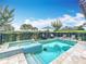 Sparkling pool and spa with lounge chairs, umbrellas, and lush landscaping at 16246 Ravenna Ct, Montverde, FL 34756
