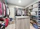 Organized walk-in closet with custom shelving, drawers, and a center island at 16246 Ravenna Ct, Montverde, FL 34756