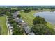 Aerial view of homes backing onto a lush green space and a serene lake at 16729 Tall Grass Ln, Clermont, FL 34711