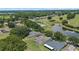 An aerial view of beautiful homes situated around a scenic pond and lush trees at 16729 Tall Grass Ln, Clermont, FL 34711