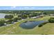 Aerial view showcasing a pond and the surrounding houses at 16729 Tall Grass Ln, Clermont, FL 34711