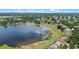 Aerial view showcasing a beautiful lake in a community surrounded by lush green landscape at 16729 Tall Grass Ln, Clermont, FL 34711