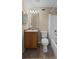 Bathroom with wooden vanity, toilet, and tub/shower combo with shower curtain at 16729 Tall Grass Ln, Clermont, FL 34711