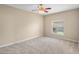 Neutral bedroom featuring a ceiling fan, plush carpet, and a window letting in natural light at 16729 Tall Grass Ln, Clermont, FL 34711