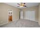 Carpeted bedroom with ceiling fan leading to an ensuite bathroom and featuring a double door closet at 16729 Tall Grass Ln, Clermont, FL 34711