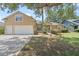 Inviting two-story home with a well-manicured lawn, mature trees, and a convenient two-car garage at 16729 Tall Grass Ln, Clermont, FL 34711