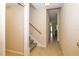 Hallway leading to stairs with a handrail and an open layout with tile flooring at 16729 Tall Grass Ln, Clermont, FL 34711