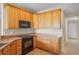 Kitchen featuring wood cabinets, speckled countertops, and modern black appliances at 16729 Tall Grass Ln, Clermont, FL 34711