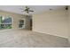 Bright living room featuring neutral paint, ceiling fan and large window at 16729 Tall Grass Ln, Clermont, FL 34711