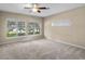 Main bedroom with neutral carpet and beautiful views from the large windows at 16729 Tall Grass Ln, Clermont, FL 34711