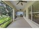 Spacious screened-in patio with ceiling fans offering serene views of the lush greenery at 16729 Tall Grass Ln, Clermont, FL 34711