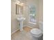 Well-lit powder room with a pedestal sink, tiled floor, and a window providing natural light at 16729 Tall Grass Ln, Clermont, FL 34711