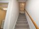 Carpeted staircase with wooden handrail leading to the upper level of the home at 16729 Tall Grass Ln, Clermont, FL 34711