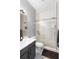 Stylish bathroom showcases subway tile shower with glass door, patterned floor, and contemporary vanity at 17404 Chateau Pine Way, Clermont, FL 34711